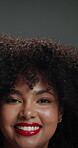 Studio, face and happy woman with afro, haircare and cosmetics for healthy natural texture or growth. Shaking, hair and person with pride for beauty, gray background and smile with makeup in Brazil