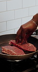 Kitchen, steak and hands of chef with pan for frying meat for cuisine, dinner and gourmet recipe. Cooking, catering and person with beef, protein and food for seasoning, flavor and culinary skills