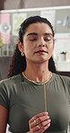Meditation, home and woman with incense stick for mindfulness, calm and spiritual awareness on break. Zen, person and stress relief with aromatherapy, breathing and healing with fragrance in house