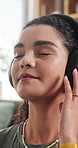 Woman, relax and dancing with headphones at house for peace, streaming podcast and calm morning. Smile, female person and listening to music with eyes closed, playlist subscription and weekend break