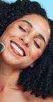 Funny, brush and woman in studio, makeup for shine and dermatology on blue background. Tools, facial foundation and person with aesthetic, laughing and product for beauty, skincare and cosmetics