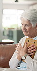 Thinking, hug and old woman with photo frame for grief, nostalgic memory or lonely in retirement. Loss, sad senior widower and embrace picture in home for broken heart, remember history or reflection