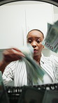 Black woman, washing machine and money laundering with corruption for theft, tax evasion and crime. African person, bills and appliance for illegal profit, fraud and pov for scam with cash at house