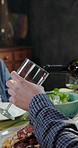 Men, hands and dining with wine bottle for festive feast, celebration and bonding together. Friends, healthy food and social gathering with toast for alcohol serving, dinner drink and party in home