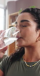 Drinking water, thirsty and woman in home, fitness for wellness and break for exercise. Apartment, tired and person in living room, liquid for hydration and refreshing for health benefits and detox