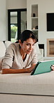 Relax, reading and woman with tablet on sofa, typing message response and laughing for post caption. Home, thinking and mature person with tech for online communication, happy and idea for joke