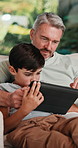 Tablet, relax and father with child on sofa in home for educational game on app for bonding. Happy, family and dad with kids for online gaming together on digital technology in living room at house.