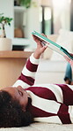 Child, relax and elearning with tablet in house, growth or skill development with assignment on web. Online education, kid and girl with tech for knowledge, research and digital activity in home