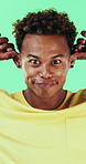 Goofy, funny face and black man on green background for humor, joke and meme in studio. Portrait, excited and comedy with silly African person with comic smile, quirky personality or expression