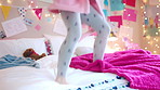 Happy, jumping and child on bed with energy for playing, fun and freedom with blanket in home. Childhood, bedroom and girl with game, toys and movement for holiday, weekend and break in morning