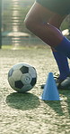 Man, legs and soccer ball with cone for training, exercise and fitness outdoor for competition practice. Athlete, person and football player on field for running drill, sport performance and workout.