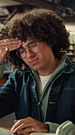 Library, laptop and student with headache, stress or fatigue with education pressure in college. Migraine, university and tired man with computer for exam fail, assignment deadline and burnout