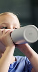 Tennis, girl or child drinking water on court with break, development or hydration for sport practice. Young kid, training recovery or bottle at padel club with refreshing liquid, wellness or fitness