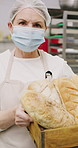 Face, mask and woman with bread in bakery, professional entrepreneur and confidence for food industry. Portrait, kitchen and mature baker with ppe for health code compliance, pride and pastry basket