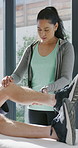 Physiotherapist, legs and patient in office for knee pain, muscle or recovery for mobility. Helping, checkup and chiropractor with healing, exercise and rehabilitation in exam for physical therapy
