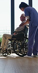 Caregiver, comfort and senior man in wheelchair for checkup, medical support and rehabilitation. Nurse, talking and elderly person with disability, assisted living and recovery reassurance at house