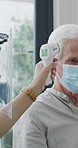 Healthcare, mask and thermometer with nurse and senior man in home living room for checkup. Appointment, ppe or temperature with caregiver and elderly patient in apartment for medical diagnosis