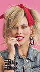 Face, retro and flirty woman in studio with fashion, accessories and 80s style. Blow kiss, stylish and edgy person with confident, cosmetics and funky jewelry for creative portrait on pink background