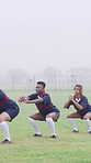 Fitness, team or women with squat on field, warm up exercise or drill for match preparation. Outdoor mist, rugby player or people with stretching routine for game, workout and space for practice