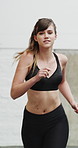 Running, sports and woman in city for exercise, cardio workout and fitness training in morning. Runner, athlete and person with active hobby for wellness, health and endurance for speed in town