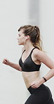 Running, fitness and woman in city with earphones for exercise, cardio workout and training. Runner, sports and person with active hobby for wellness, health and endurance with music, audio and track