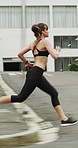 Running, sports and woman in city with earphones for exercise, cardio workout and training. Runner, fitness and person with active hobby for wellness, health and endurance with music, audio and track