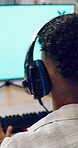 Gamer, headphones and teen with computer screen in home, entertainment or live streaming on website. Gaming, online and playing esports with technology, back and person with subscription in house