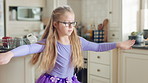 Child, home and dance with energy, freedom and creative performance with dress for music in kitchen. Girl, kid and moving to audio at house with talent for rhythm, tutu and development on weekend
