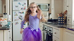 Dancing, face or child with tutu in kitchen, steps rehearsal or practice for coordination development. Weekend fun, childhood and girl ballerina with music for movement, energy and portrait in home