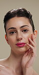 Beauty, face and touching with woman in studio for cosmetics or dermatology results. Makeup, serious and skincare with confident person feeling smooth skin on gray background for hydration benefits