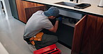 Fixing, sink and man with tools in kitchen, drainage system maintenance and plumbing skills in house. Handyman, home  repair and pipe improvement with equipment, installation and leak prevention