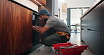 Sink, repair and man with tools in kitchen, drainage system maintenance and plumbing skills in house. Serious, plumber and pipe improvement with equipment, installation and leak prevention in home