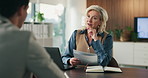 Office, discussion and businesswoman with paperwork for job interview, HR and meeting with candidate. Business, recruiter and mature person with questions for vacancy, resume and onboarding process