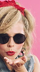 Woman, sunglasses and blow kiss in studio with vintage fashion, red lipstick and flirt on pink background. Girl, shades and hand gesture with retro style, cosmetics and smile with pout for makeup
