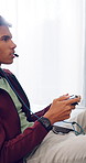 Man, headphones and gamer with controller for esport, match or online tournament on sofa of home. Competition, teenager or streamer with video game, challenge or user experience in house living room