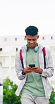 Walking, phone and teen boy typing outdoor in city for location search, communication and social media. Happy student, technology and connection for maps app, website and headphones in road by space
