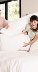 Happy, children and playing with pillow in bedroom for fun, playful interaction and friendly battle. Smile, siblings or combat with cushion, morning activity and funny games for weekend break in home