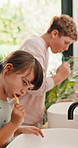 Kids, oral hygiene and brushing teeth in home for health, dental wellness or plaque removal. Toothbrush, clean mouth and girl in bathroom for gum care, morning habit and development with sibling