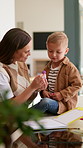 Mom, boy and learning with books in home for development, talk or show stationery for drawing. People, mother and kid with eraser, pencil or teaching guide for education with bonding at family house