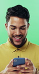 Phone, typing and man in studio, funny notification or social media meme on green background. Mobile, smile and person on internet for chat, online connection or laugh at gif with text message
