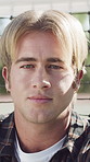 Face, serious and man outdoor for travel, adventure trip and holiday abroad for spring break. Portrait, male person or fence with confidence, morning commute and vacation overseas for weekend getaway