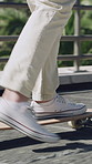 Legs, man and skateboard on bridge in city for commute, eco friendly transport and adventure. Skater, shoes and skateboarding in urban town for sustainable travel, morning journey and zero emission