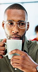 Man, coffee and laptop in office with report, project management and review with glasses at company. Person, mug and beverage with tea, insight or computer for solution with career at creative agency