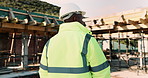 Thinking, construction and back of black man with helmet for planning, building and site inspection. Civil engineer, outdoor and person with reflection for infrastructure, project and repair with ppe