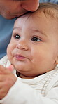 Forehead, kiss and baby with dad in house, affection and comfort for child with sensory development. Love, man and bonding with son, teething and support for boy with cognitive growth in apartment