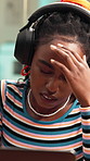Woman, headphones and laptop in office with headache, music and stress for social media management. Black person, migraine and audio tech in workplace with computer, podcast and marketing crisis.