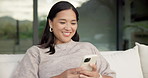 Relax, typing and Asian woman with phone on couch, check notification and watch social media video. Online conversation, chill or person with smile for blog post by home, mobile or browsing internet