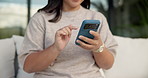 Woman, hands and typing with phone on sofa for social media, communication or online texting. Female person, user or scrolling with mobile smartphone or smile for network connection or chat in home