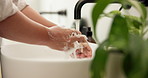 Person, hands and soap with water in sink for hygiene, disinfection or cleanliness in home. Closeup, faucet or cleaning dirt with tap in basin for protection, bacteria or germ removal in house