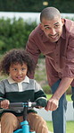 Teaching, bicycle and father with kid in nature for bonding, activity or love together on weekend. Happy, learning and dad with child with cycling on bike outdoor in park for connection with family.